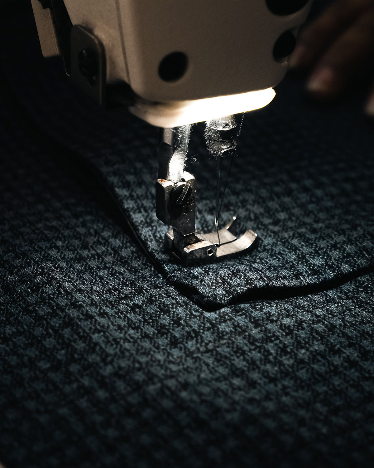 Máquina de coser pasando una costura sobre la tela