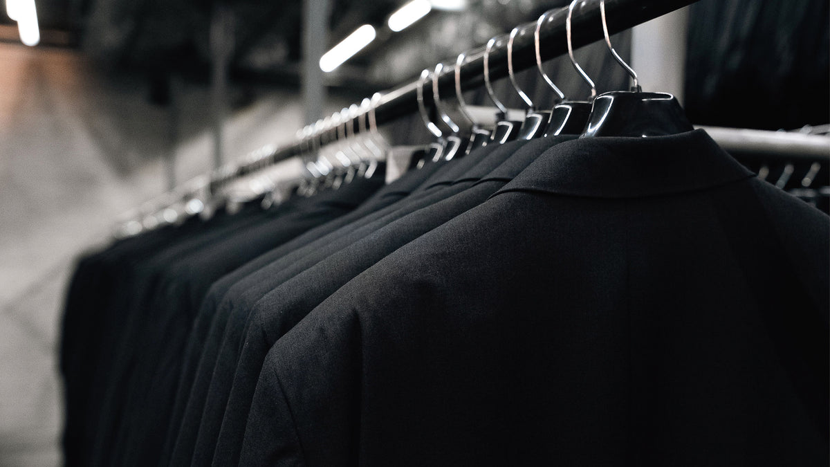 Sacos oscuros colgados en un perchero de la fábrica